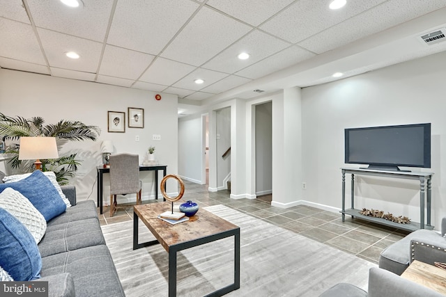 tiled living room with a paneled ceiling