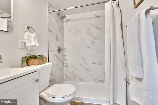 bathroom with curtained shower, vanity, and toilet