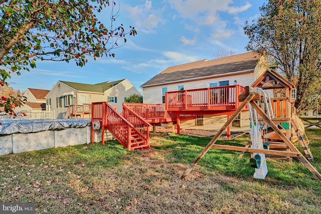 view of play area with a lawn and a pool side deck