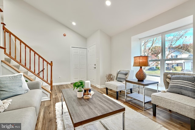 living room featuring high vaulted ceiling and wood-type flooring