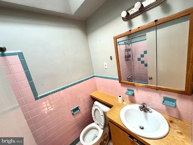 bathroom featuring vanity, toilet, and tile walls