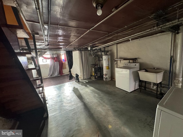 basement featuring water heater, sink, and washer / dryer