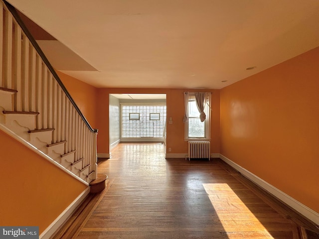 entryway with radiator and hardwood / wood-style flooring