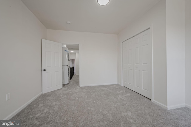 unfurnished bedroom with light carpet, a closet, and white fridge