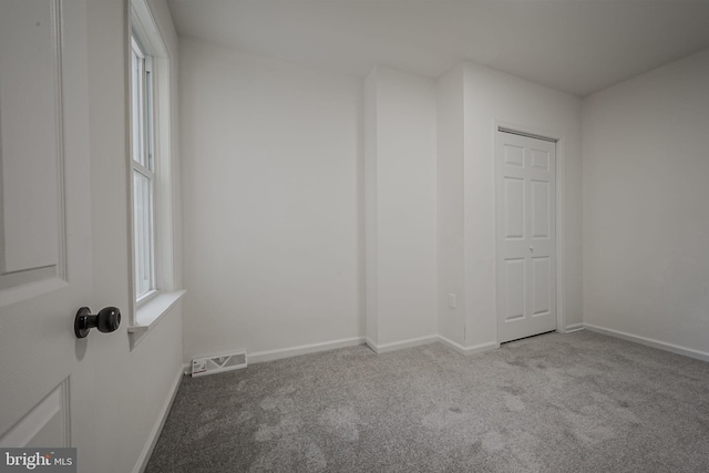 unfurnished room with light colored carpet