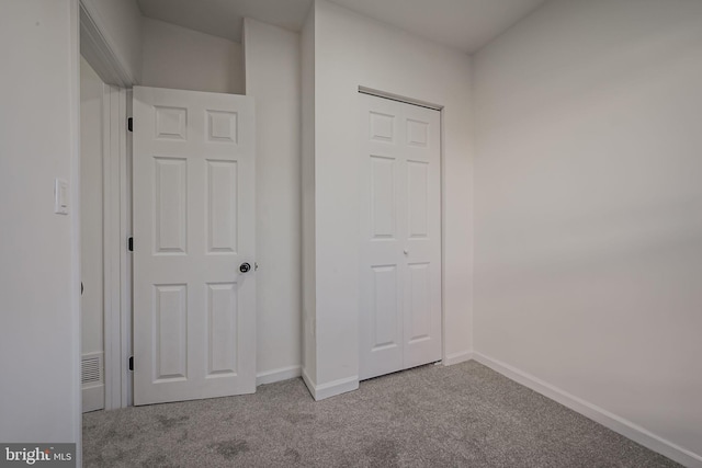 interior space with a closet and light colored carpet