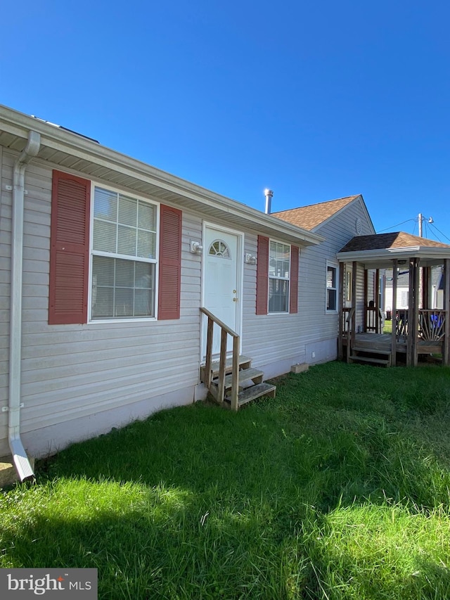 view of front of property featuring a front yard and a deck