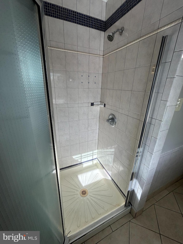 bathroom with tile patterned flooring and a shower with door