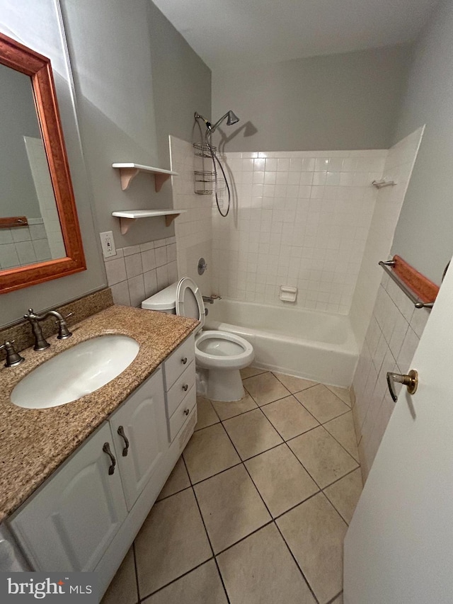 full bathroom with toilet, tiled shower / bath combo, vanity, and tile patterned floors