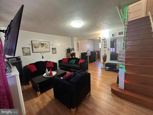 living room with wood-type flooring and a textured ceiling