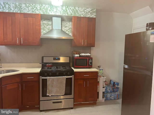 kitchen with gas range, light tile patterned floors, wall chimney range hood, and sink