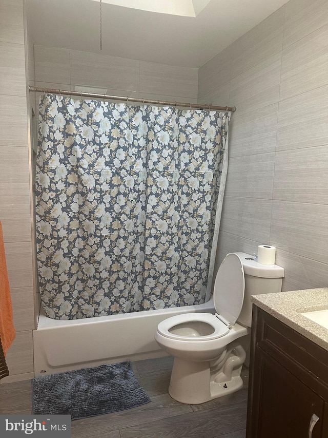 bathroom featuring toilet, vanity, tile walls, and hardwood / wood-style flooring