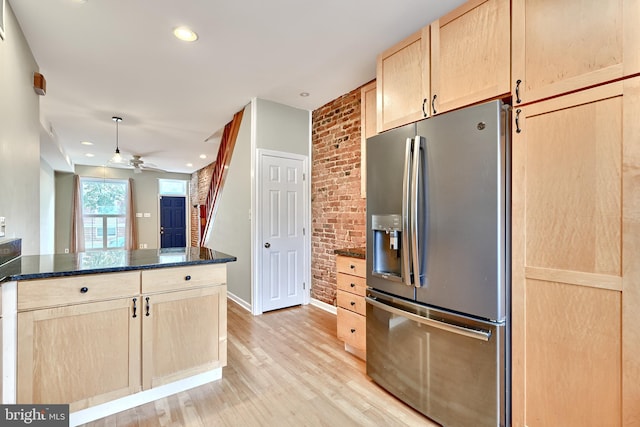 kitchen featuring light hardwood / wood-style floors, stainless steel fridge with ice dispenser, ceiling fan, light brown cabinetry, and dark stone countertops