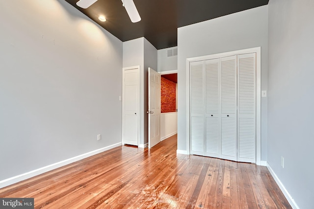 unfurnished bedroom with light hardwood / wood-style flooring, ceiling fan, and a closet