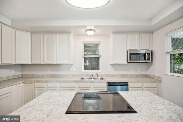 kitchen with light stone countertops, sink, white cabinets, and appliances with stainless steel finishes