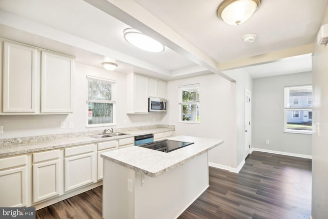 kitchen featuring a center island, black stove, dark wood-type flooring, sink, and white cabinets