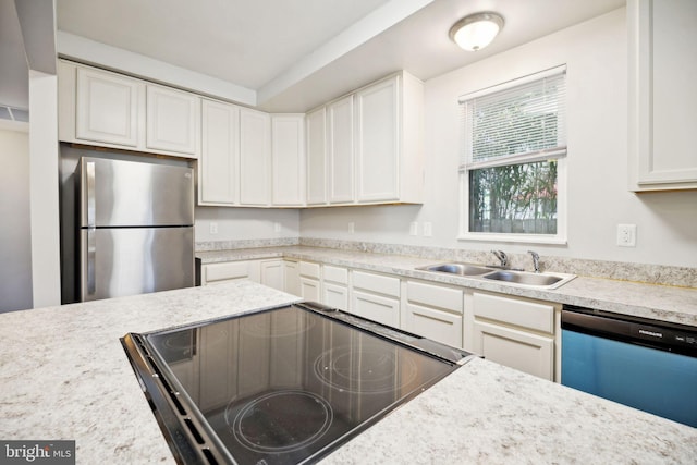 kitchen featuring white cabinets, stainless steel appliances, light stone countertops, and sink