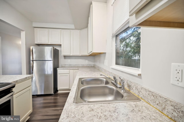 kitchen with white cabinets, appliances with stainless steel finishes, dark hardwood / wood-style floors, and sink