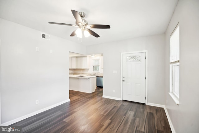 unfurnished living room featuring ceiling fan and dark wood-type flooring