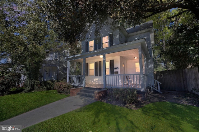 view of front of home with covered porch and a front lawn