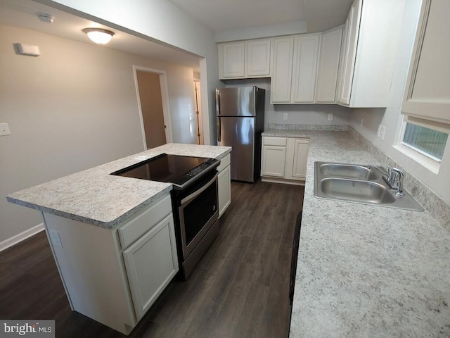 kitchen featuring appliances with stainless steel finishes, dark hardwood / wood-style flooring, a kitchen island, sink, and white cabinetry