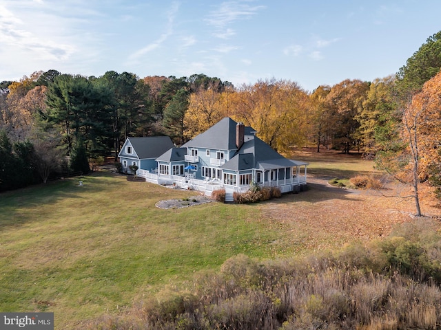 back of property with a yard and a sunroom