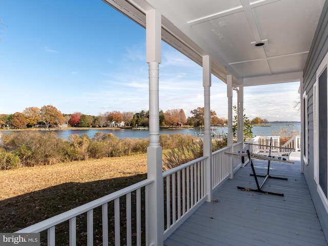 deck featuring covered porch and a water view