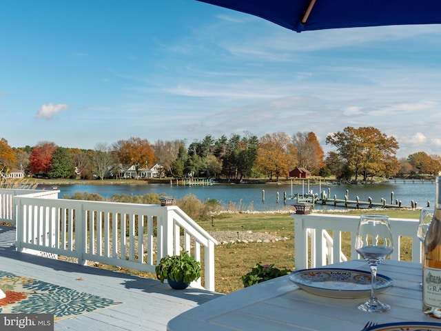 wooden deck featuring a water view and a boat dock