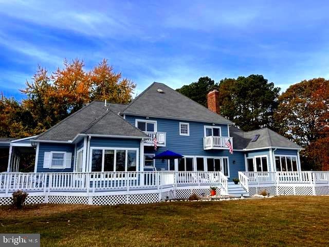 back of property featuring a deck and a yard