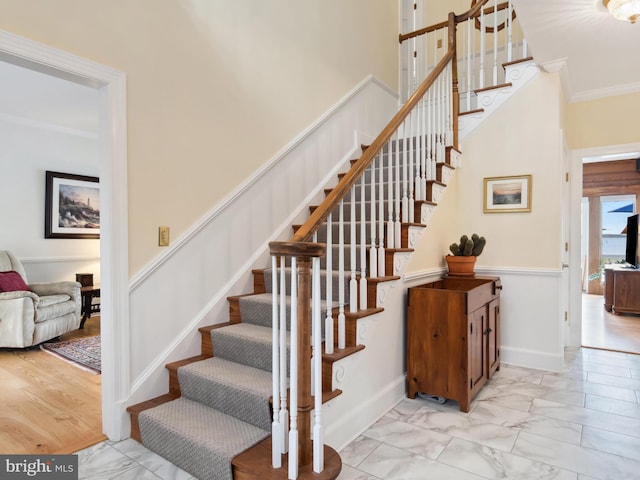 stairway featuring hardwood / wood-style floors and ornamental molding