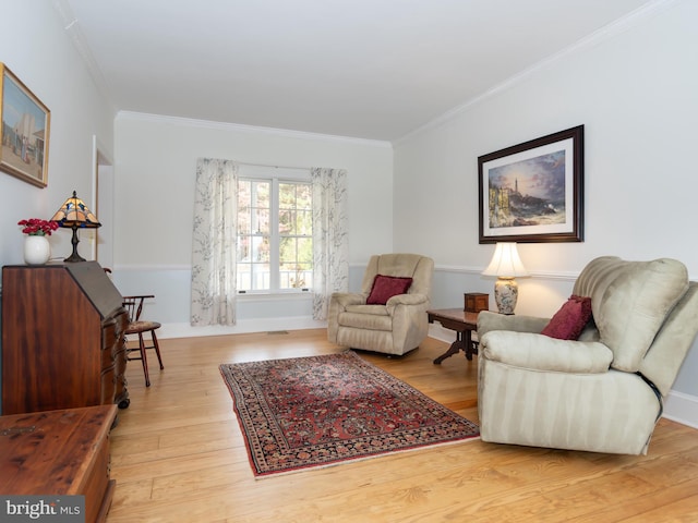 living area with light hardwood / wood-style flooring and crown molding