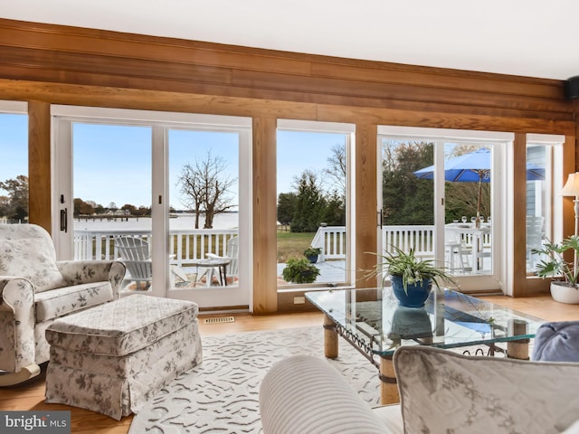 sunroom featuring a water view