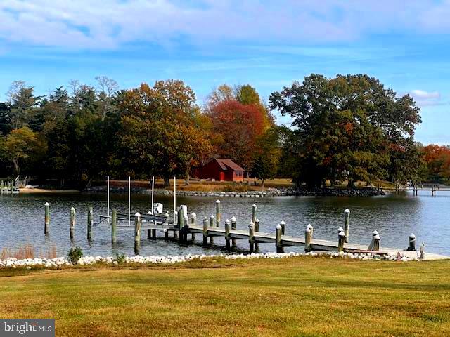 dock area featuring a lawn and a water view