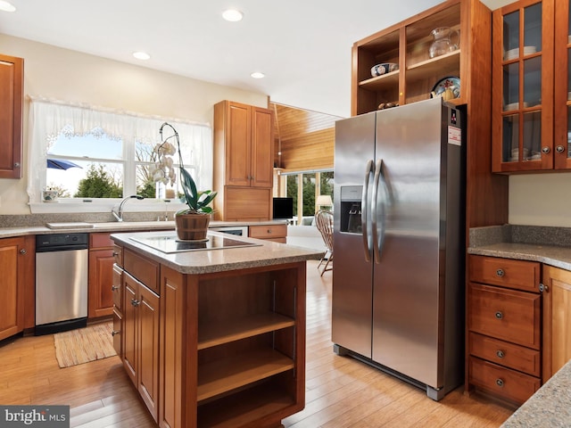 kitchen with a center island, sink, stainless steel refrigerator with ice dispenser, light hardwood / wood-style floors, and black electric cooktop