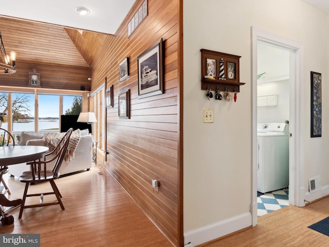 hallway with wooden ceiling, a notable chandelier, washer / clothes dryer, hardwood / wood-style floors, and lofted ceiling