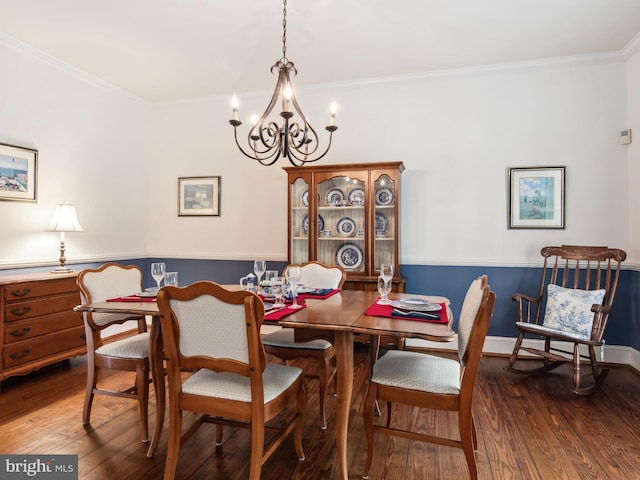 dining room featuring an inviting chandelier, crown molding, and dark wood-type flooring