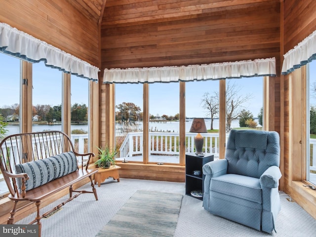 sunroom / solarium with a water view, lofted ceiling, and wood ceiling