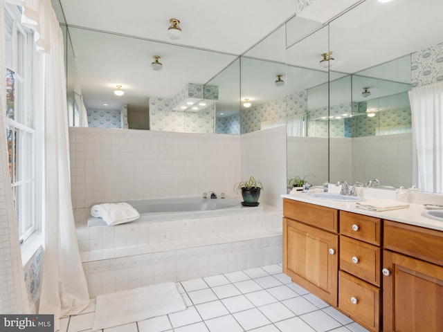 bathroom featuring tile patterned floors, tiled bath, and vanity