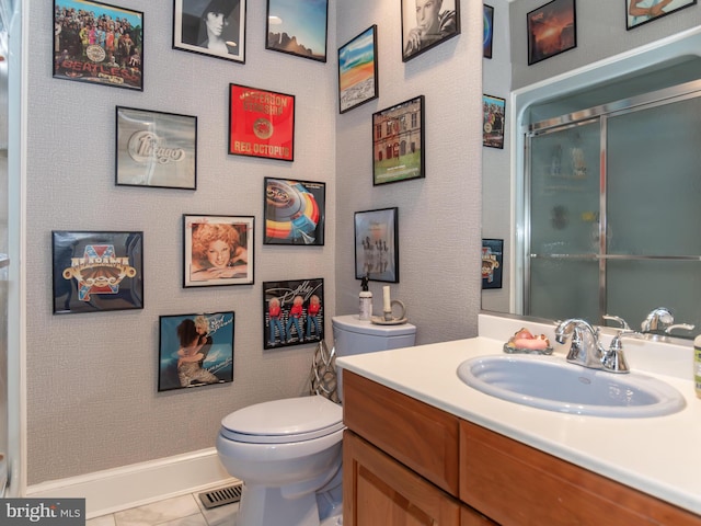 bathroom with tile patterned flooring, vanity, toilet, and walk in shower