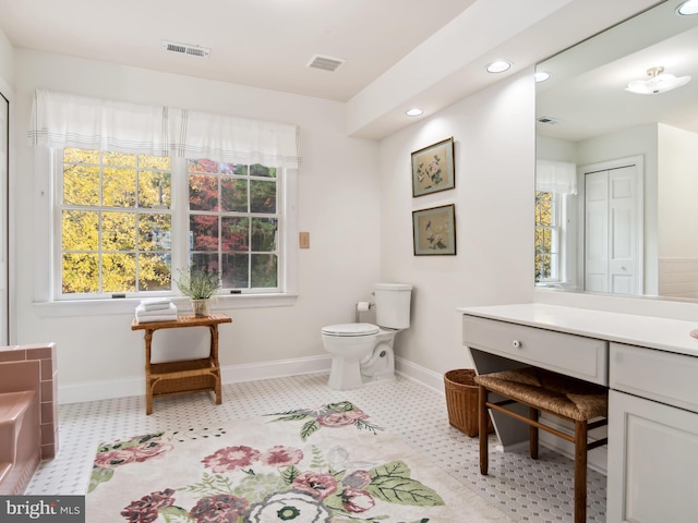 bathroom with tile patterned flooring, plenty of natural light, toilet, and vanity