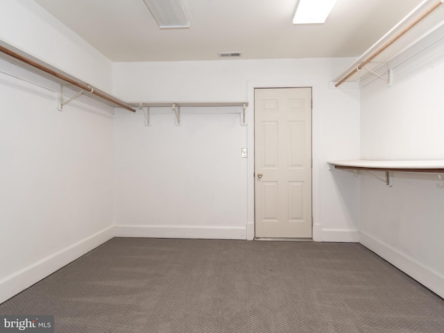 spacious closet featuring dark carpet