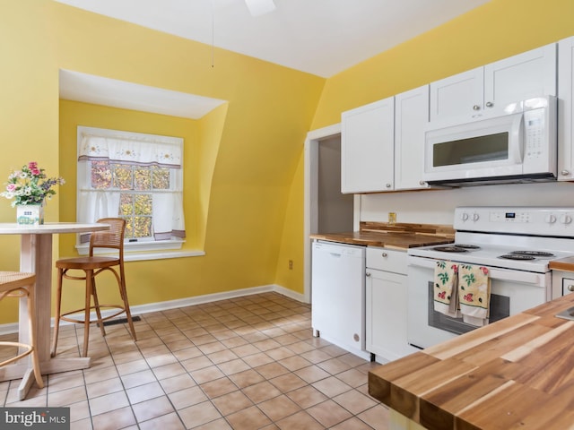 kitchen featuring light tile patterned floors, white appliances, white cabinetry, and butcher block counters