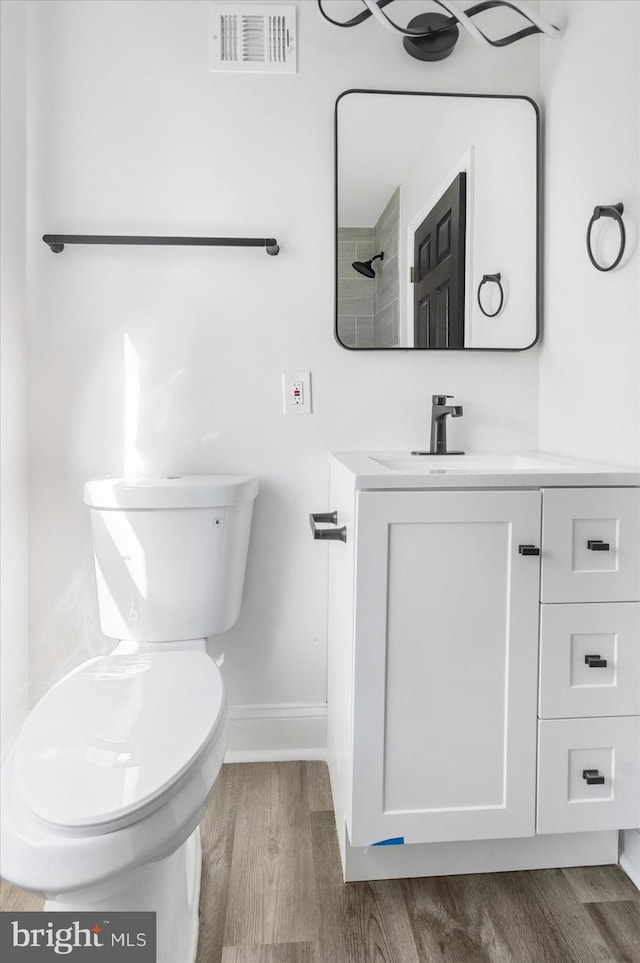 bathroom featuring toilet, vanity, and wood-type flooring