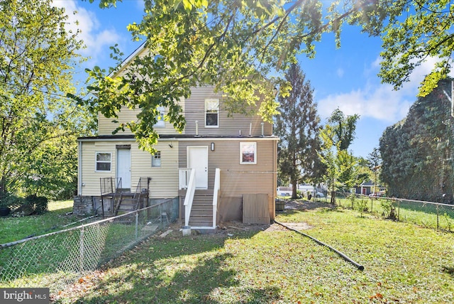 rear view of property with a lawn