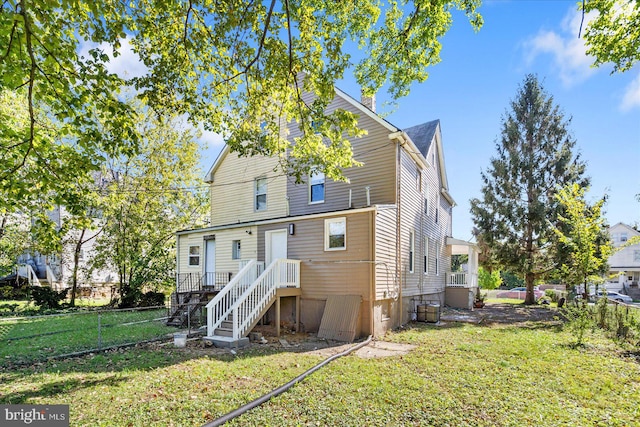 rear view of property featuring a yard