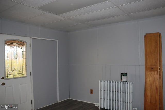 entryway featuring dark wood-type flooring, radiator, and a drop ceiling