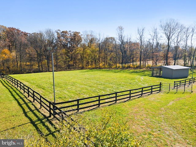 view of yard with a rural view and an outdoor structure