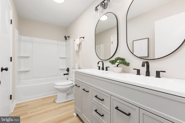 full bathroom with shower / washtub combination, hardwood / wood-style flooring, toilet, and vanity