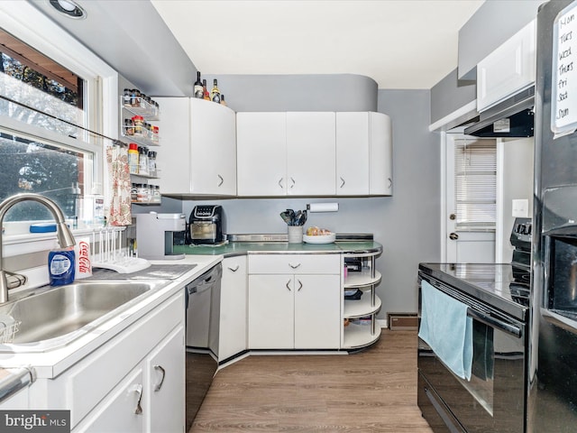 kitchen with sink, black appliances, light hardwood / wood-style floors, white cabinetry, and range hood