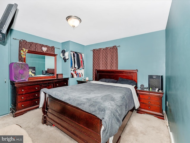 bedroom with light carpet and a closet